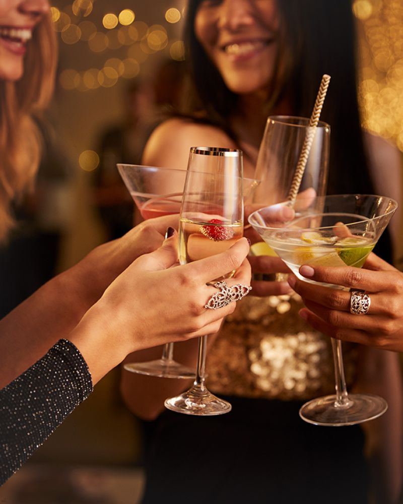 Frauen stoßen in festlicher Atmosphäre mit Cocktails an und genießen gesellige Momente.