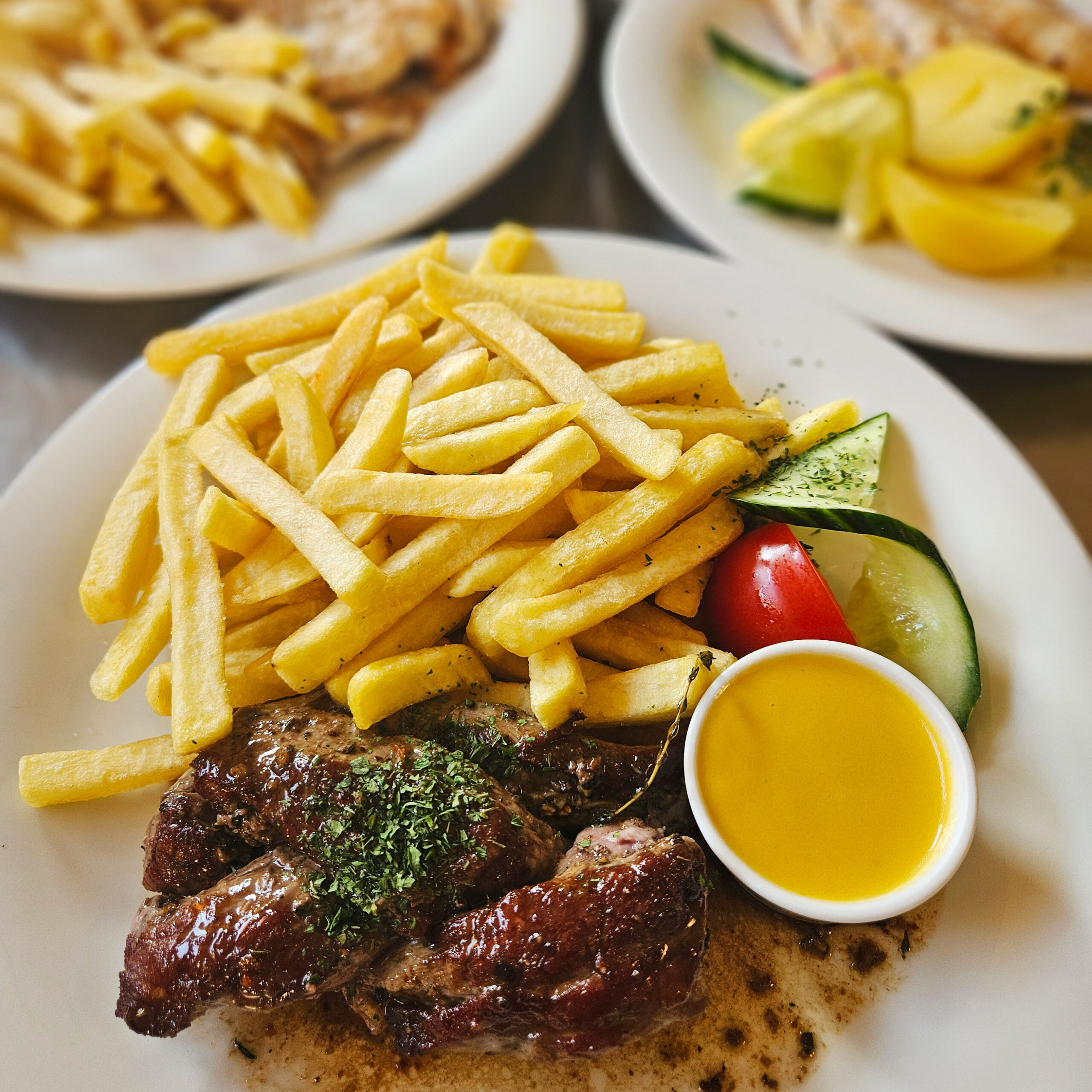 Ein Teller mit saftigem Steak, knusprigen Pommes und Salat wird im Strandcafé serviert, ideal für ein nordisches Genusserlebnis.