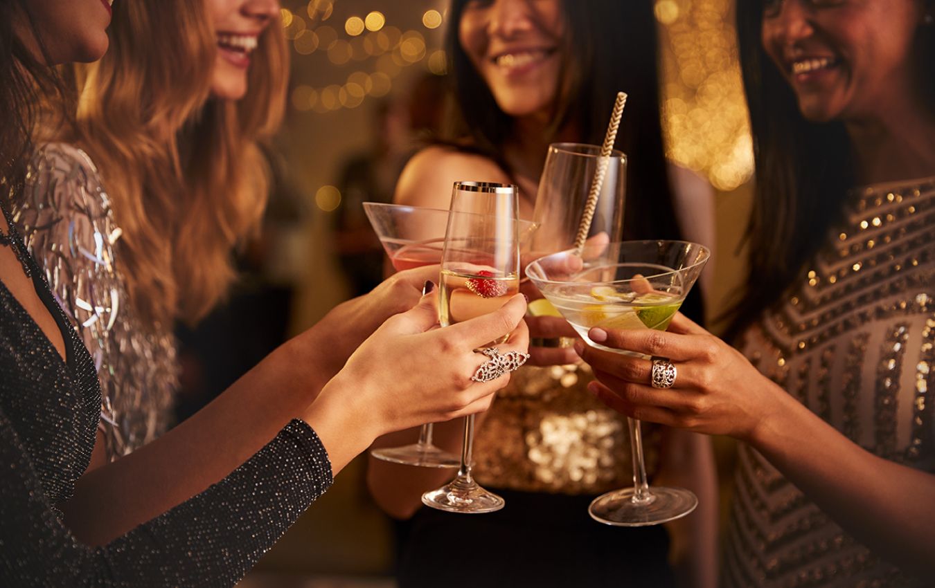 Frauen stoßen in festlicher Atmosphäre mit Cocktails an und genießen gesellige Momente.