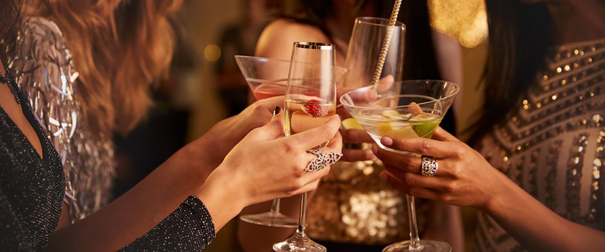 Frauen stoßen in festlicher Atmosphäre mit Cocktails an und genießen gesellige Momente.