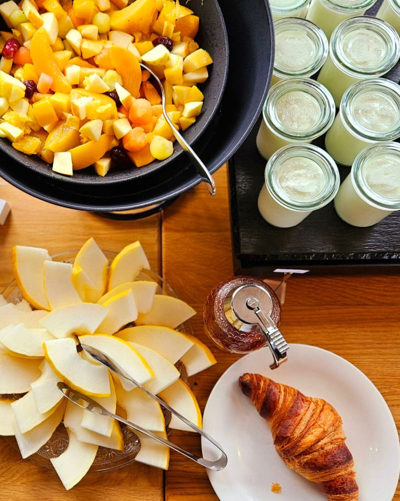Ein reichhaltiges Frühstücksbuffet im Strandcafé mit frischem Obstsalat, Joghurt, Croissant und Marmelade erwartet die Gäste.