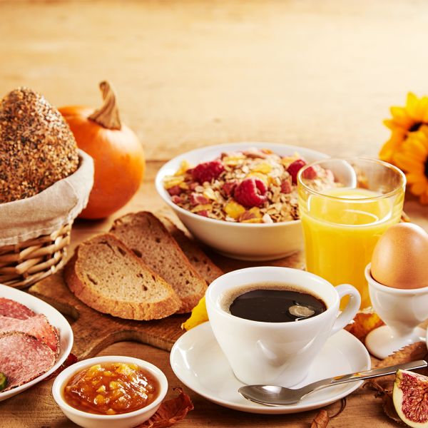Ein reichhaltiges Frühstück mit Brötchen, Aufschnitt, Müsli, Orangensaft und Kaffee lädt zum Genießen im Strandcafé ein.