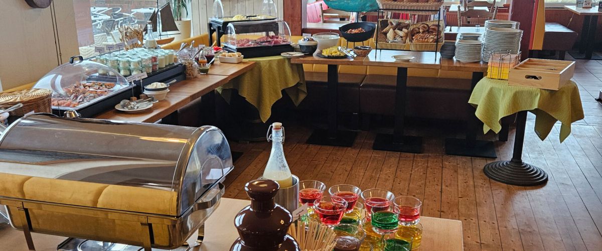 Ein reichhaltiges Frühstücksbuffet mit Schokoladenbrunnen und Meerblick lädt im Strandcafé zu einem genussvollen Start ein.